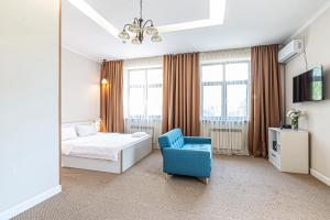 a hotel room with a bed and a blue chair at AYKUN Hotel in Almaty +52 photos