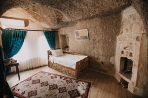 a bedroom with a bed and a fireplace at Holiday Cave Hotel in Göreme +273 photos