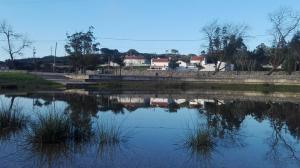 Arieiro的住宿－Pro Touristic Montejunto Villas，一片水体,有树和建筑背景