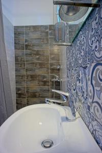 a bathroom with a white sink and some tiles at Dimitra Apartments in Kanali