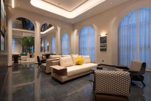a living room with a couch and chairs and windows at Dream Palace Ben Thanh Grand Hotel in Ho Chi Minh City +63 photos