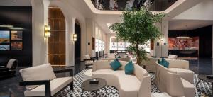 a lobby with white couches and a plant at Dream Palace Ben Thanh Grand Hotel in Ho Chi Minh City