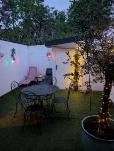 a patio with a table and chairs and a tree at La parenthèse in Ault