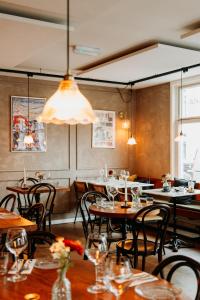 a restaurant with tables and chairs and a chandelier at La Paulowna Boutique Hotel in The Hague