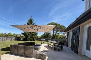 a patio with a table and an umbrella at Maison Salignac 9 personnes in Salignac Eyvigues