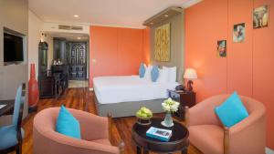 a hotel room with a bed and two chairs at Memoire Siem Reap Hotel in Siem Reap