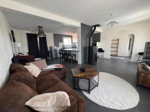 a living room with a couch and a table at Maison Salignac 9 personnes in Salignac Eyvigues