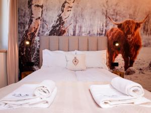 a bedroom with a bed with a painting of a cow at Willa Chrycówka - Jacuzzi, Basen, Sauna in Kościelisko +80 photos