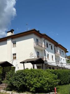 a large white building with a fire hydrant in front of it at Hotel Mezzolago in Calceranica al Lago