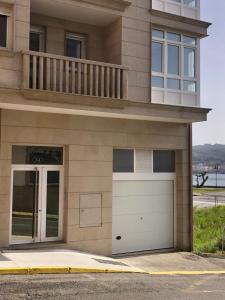 a building with a garage door and a balcony at Salitre - Boa Onda in Cee