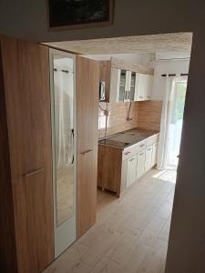a kitchen with wooden cabinets and a counter top at Studio Apartman GRACIJA in Herceg-Novi