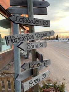 a street sign with direction signs on the side of a road at Härjulfs hus in Lillhärdal