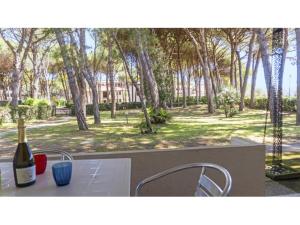 a table with a bottle of wine and two chairs at Sotto il Pino 14 in Eraclea Mare