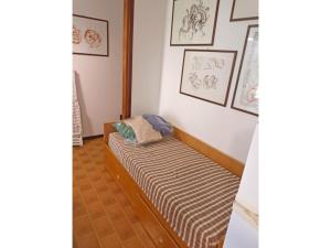 a room with a bed with a striped couch at Sotto il Pino 14 in Eraclea Mare