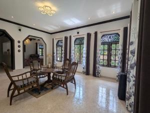 a dining room with a table and chairs and windows at Arangala View in Elhanyaya