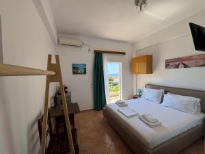 a bedroom with a bed and a large window at Rexhos Studios in Himare