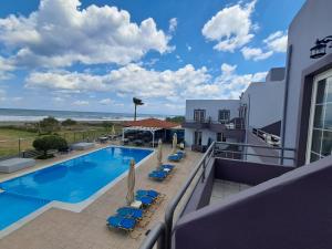 a view of the pool and beach from the balcony of a resort at Haridimos Apartments in Tavronitis