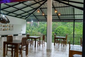 a dining room with tables and chairs and a balcony at Ella RV Heaven World Hotel in Ella