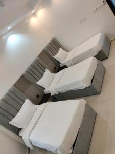 two beds in a room with white sheets and pillows at شالية الكناري in Taif +39 photos