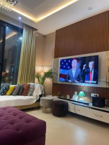 a living room with a couch and a flat screen tv at Lux Bliss Bed & Breakfast in Amritsar