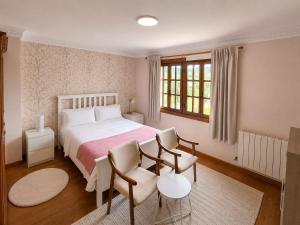a bedroom with a bed and a table and chairs at Posada Adela in Santillana del Mar +37 photos