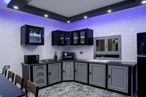 a kitchen with black and white cabinets and a sink at Villa BBS in Ghlissia