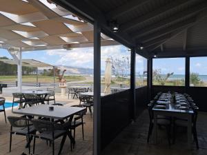 a restaurant with tables and chairs with a view of the ocean at Haridimos Apartments in Tavronitis