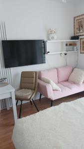 a living room with a pink couch and a chair at Uzdrowiskowa "Trzy Korony" in Świnoujście