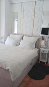 a bed with white sheets and pillows in a bedroom at Uzdrowiskowa "Trzy Korony" in Świnoujście