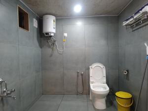 a bathroom with a toilet and a shower stall at Hope Hostels - Munnar in Munnar +43 photos