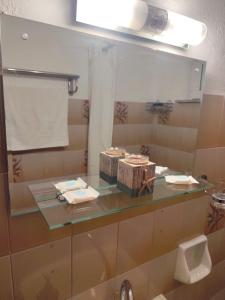 a bathroom with a glass counter with a mirror at Garden studio N4 in Archangelos
