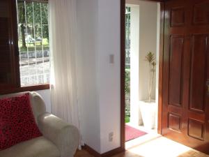 a living room with a chair and a window at Casa Ditesta in Caxias do Sul
