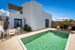 a swimming pool in the backyard of a villa at Gemini Villas in Theologos