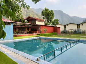 a swimming pool in front of a house at Aqua Forest River Resort in Bijni