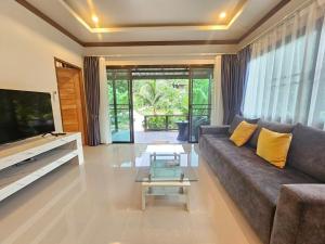 a living room with a couch and a tv at Bang Po Hut in Ban Bang Po