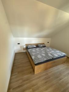 a bedroom with a bed and a wooden floor at Apartma Luvita in Golnik