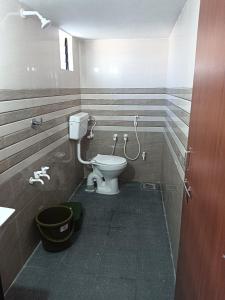 a bathroom with a toilet and a bucket at Shiva Homestay Dwarka in Dwarka