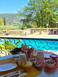 a table with plates and bowls of food on a balcony at Villa Manoe in Draguignan