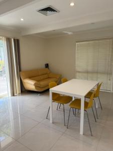 a living room with a table and chairs and a couch at Bright Double Room N Winston Hills in Toongabbie