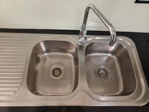 a stainless steel kitchen sink with a faucet at Bright Double Room N Winston Hills in Toongabbie