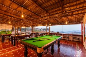 a pool table in a room with tables and benches at Zostel Ooty, Pudumund in Ooty +42 photos