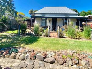 a house with a fence and a rock garden at Homesaway Cottage in Kyneton
