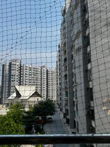 a view of a tall building from behind a net at Kavya royal in Mathura