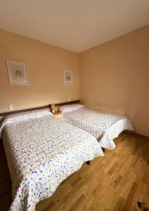 a bedroom with two beds and a wooden floor at Casa Ramona en Foz in Foz +4 photos