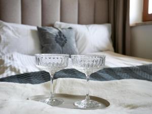 two wine glasses sitting on top of a bed at Willa Chrycówka - Jacuzzi, Basen, Sauna in Kościelisko