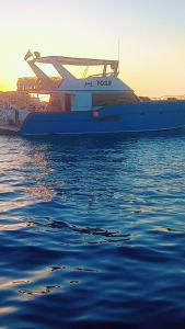 ein großes Boot, das bei Sonnenuntergang im Wasser liegt. in der Unterkunft Yosr in Hurghada