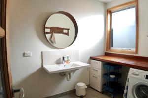 a bathroom with a sink and a mirror at Homesaway Cottage in Kyneton +28 photos