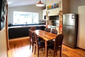 a kitchen with a wooden table and a refrigerator at Homesaway Cottage in Kyneton
