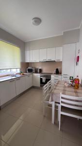 a kitchen with white cabinets and a table and chairs at Gloria's House in Lagoa +17 photos