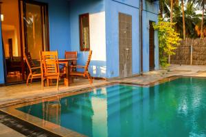 a table and chairs next to a swimming pool at Nayan's Paradise in Kottanitivu